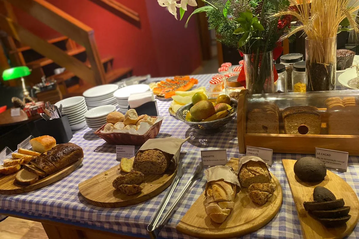 Mesa do café da manhã com pães de fermentação natural e frutas frescas