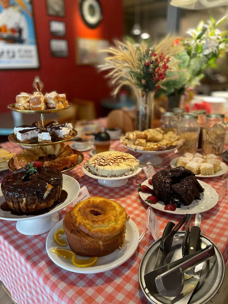 Mesa de doces do café da manhã com bolos caseiros e torre de salgados